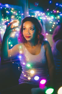 Woman in illuminated music concert at night