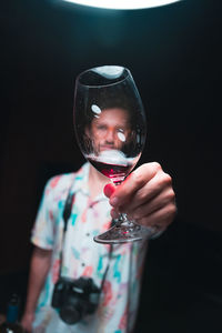 Close-up of boy holding glass against black background