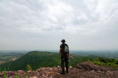 Rear view of hiker standing on mountain witnessing beautiful scene