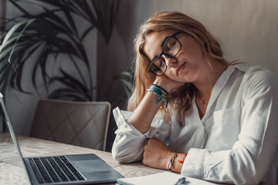 Young woman using laptop while sitting at home