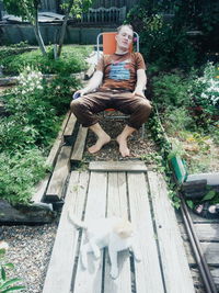 Woman sitting on seat in yard