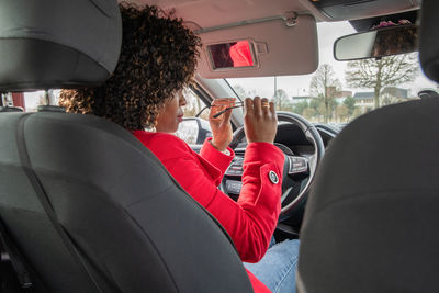 African american woman driver putting on sunglasses on sunny day before driving