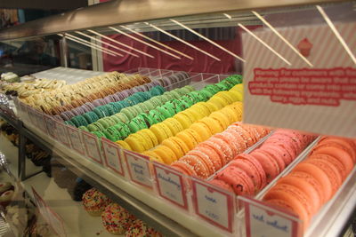 Colorful macaroons in display cabinets for sale at store