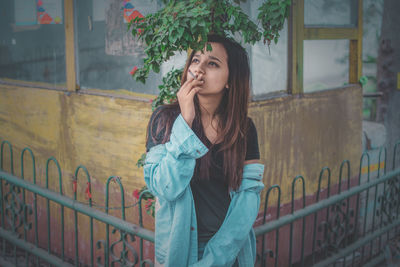 Beautiful young woman against wall