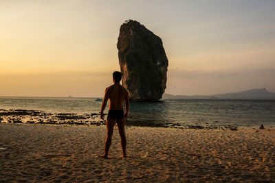 Man standing on rock at beach
