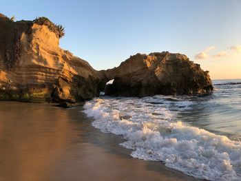 Scenic view of sea by cliff against sky