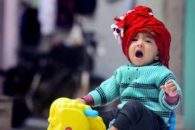 Portrait of cute girl wearing turban yawning at home