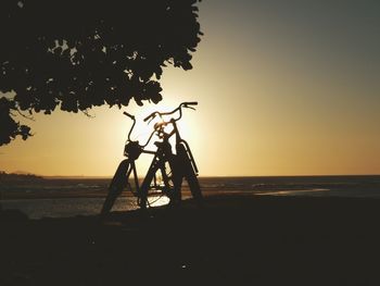 Silhouette people on beach against sky during sunset