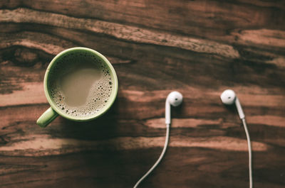 Coffee cup and headphones on table