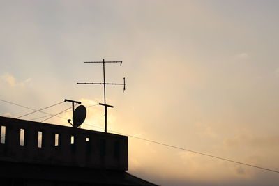 Low angle view of antenna on terrace against sky