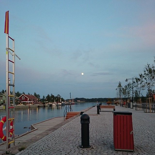 sky, water, building exterior, built structure, sea, tranquility, street light, architecture, tranquil scene, cloud - sky, nature, scenics, outdoors, tree, pier, beauty in nature, no people, railing, lighting equipment, empty