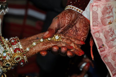 Close-up of bridegroom holding bride hand in wedding
