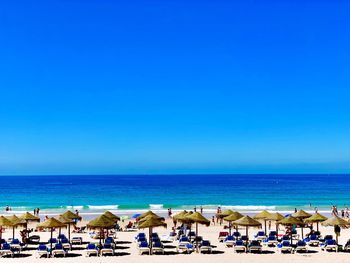 Scenic view of beach against clear blue sky