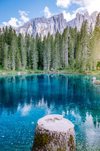 Scenic view of lake by mountains against sky