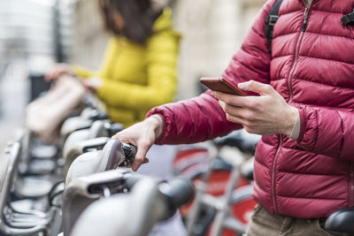 Midsection of woman using mobile phone