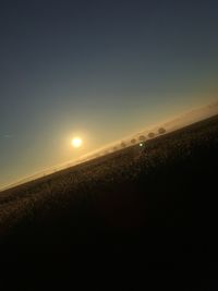 Scenic view of field against clear sky during sunset