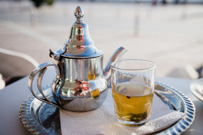 Traditional moroccan tea pot with a cup outside ready to drink