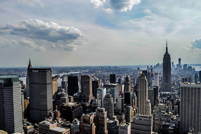 Aerial view of city buildings against cloudy sky