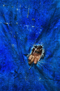 Close-up of child peeking through blue plastic