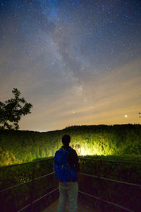 Man standing on field against sky at night