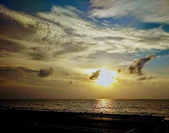 Scenic view of sea against dramatic sky during sunset