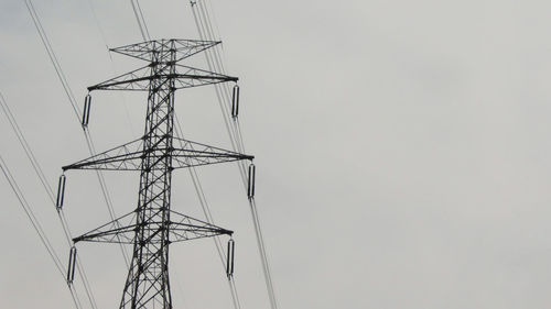 Low angle view of electricity pylon against sky