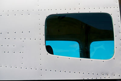 Close-up of airplane window against sky