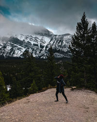 Full length of woman standing against snowcapped mountain during winter