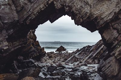 Scenic view of sea seen through arch shaped rock formation