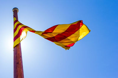 Low angle view of american flag against clear blue sky