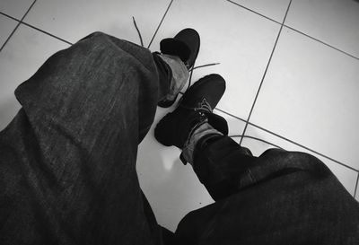 Low section of man standing on tiled floor