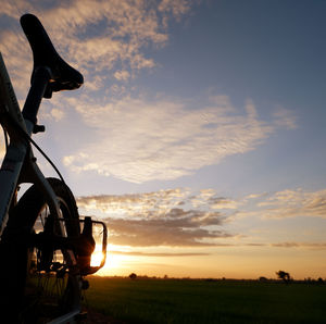 Scenic view of agricultural field against sky during sunset