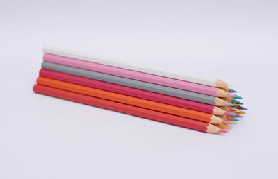 High angle view of multi colored pencils against white background