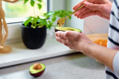 Ripe avocado in woman hands, healthy breakfast