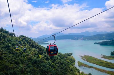 Overhead cable car over sea against sky