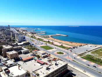 High angle view of city by sea against clear sky