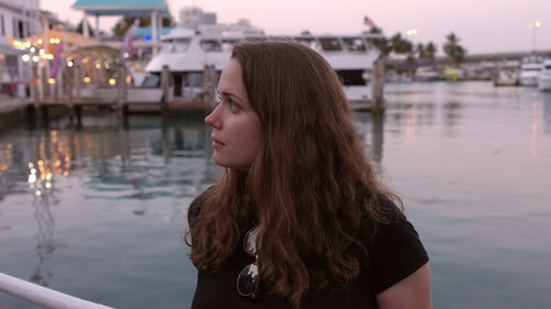 Side view of young woman looking away against lake