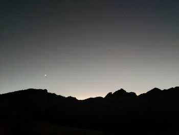Low angle view of silhouette mountain against clear sky
