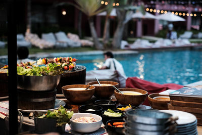 Various food on table against swimming pool