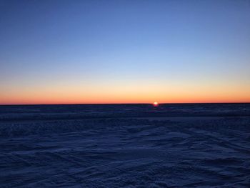 Scenic view of sea against clear sky at sunset