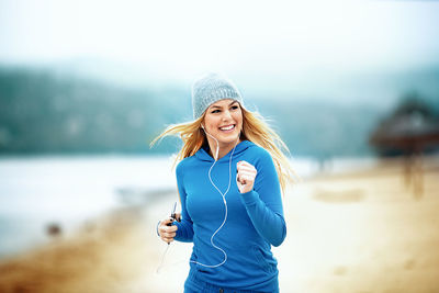 Portrait of happy woman running on mobile phone