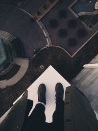 Low section of man standing on building terrace against street