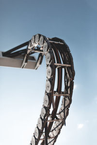 Low angle view of abandoned metallic structure against blue sky