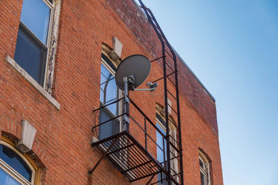 A fire escape on the side of a building and a satellite dish