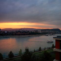 Scenic view of river against cloudy sky at sunset