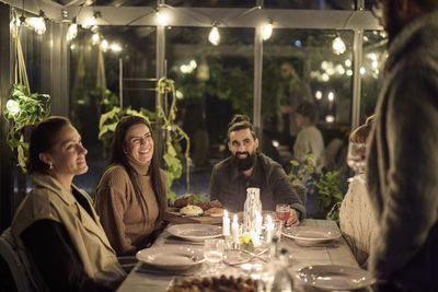 Happy friends having evening meal together