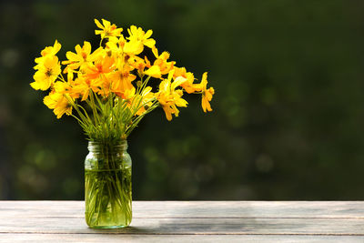 Close-up of yellow flower vase on table