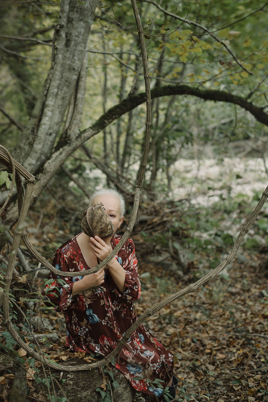 plant, real people, one person, tree, lifestyles, land, leisure activity, nature, women, forest, child, childhood, day, casual clothing, branch, girls, three quarter length, field, outdoors, innocence