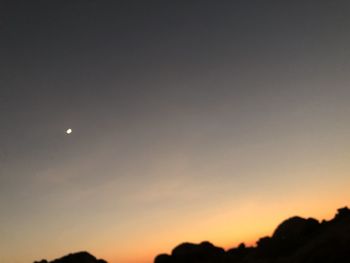 Scenic view of silhouette moon against sky at sunset