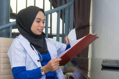 Young woman looking down while standing on paper